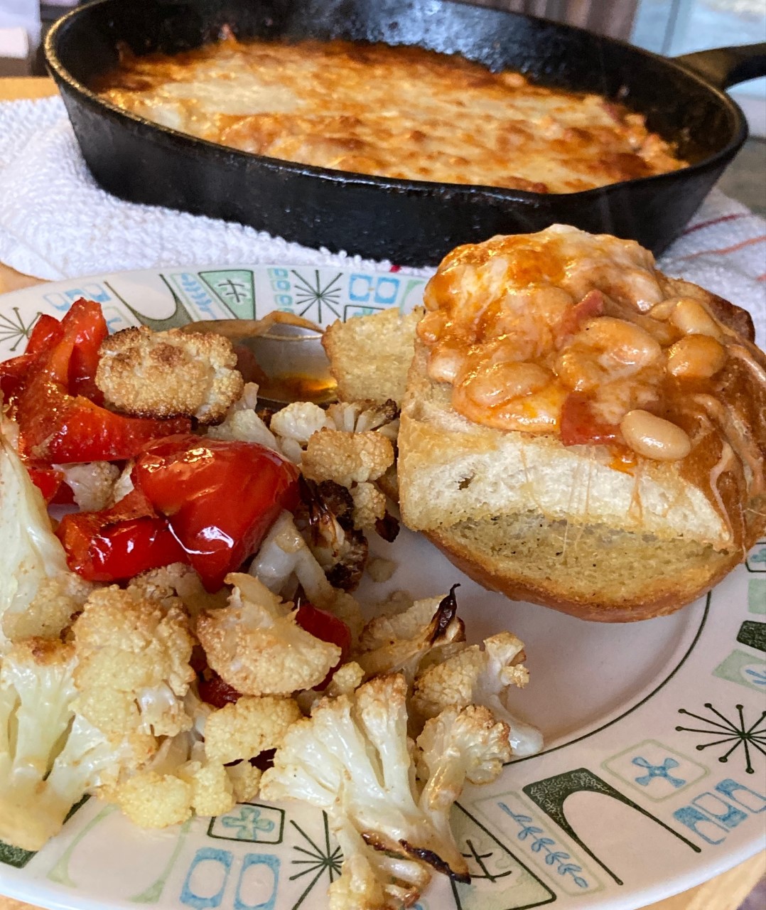 Picture of josie's dish (pan full of cooked lava, some on crucnchy toast, and roasted veggies)