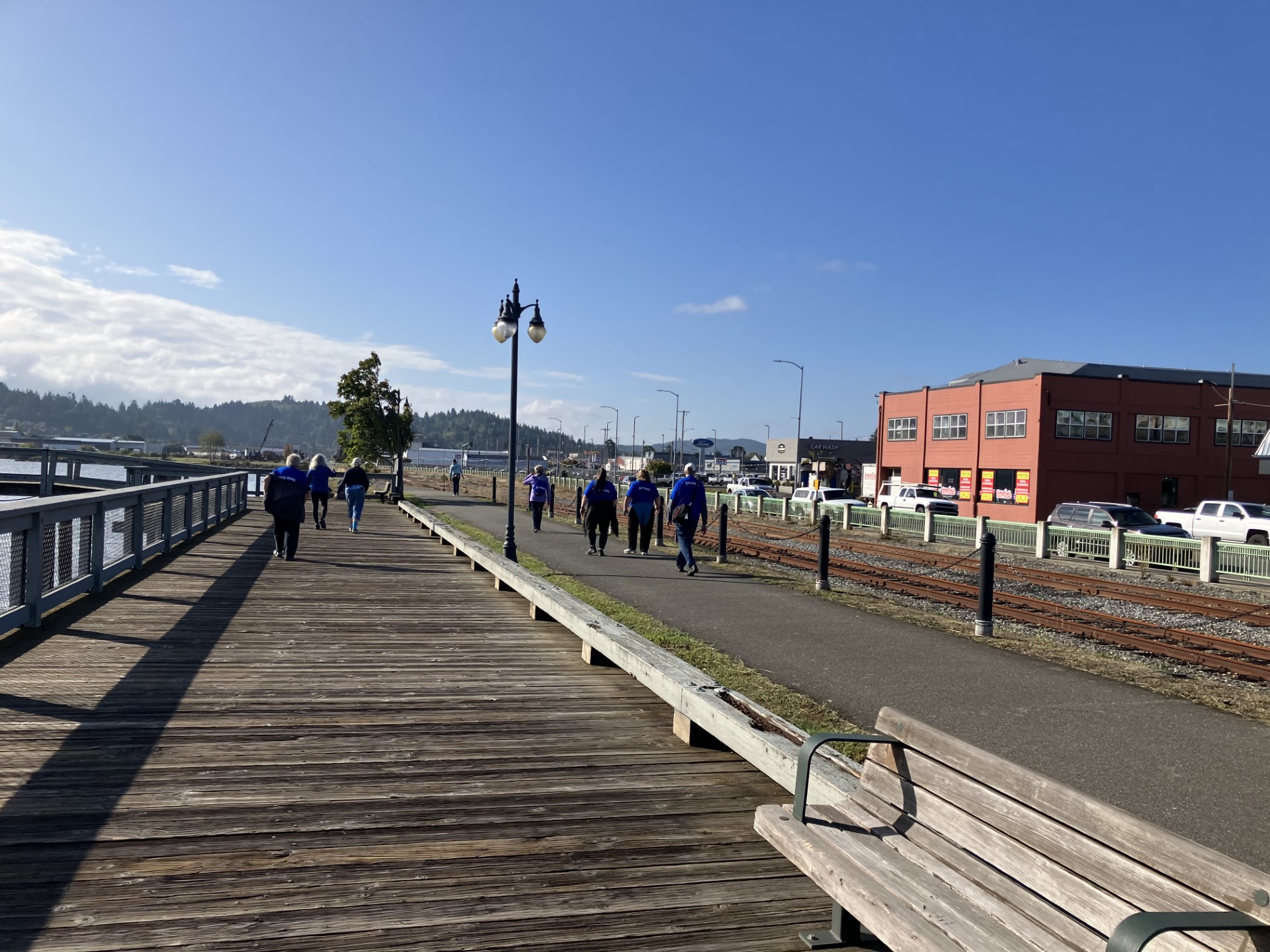 pic from behind of Sole Mates walking Boardwalk trail, blue sky and clouds in background