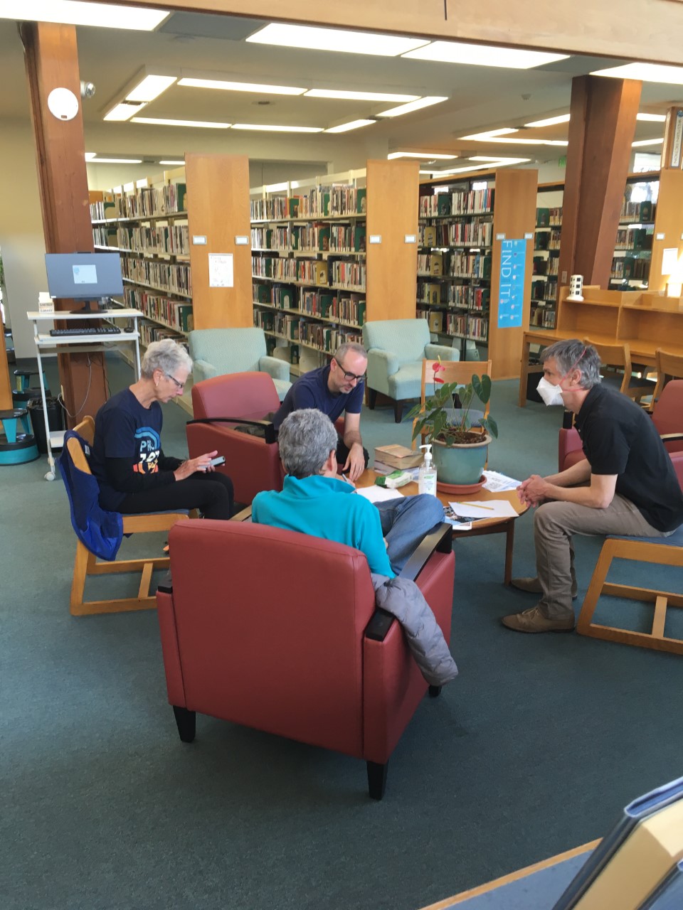 Spanglish group (two women, two men) conversing in library